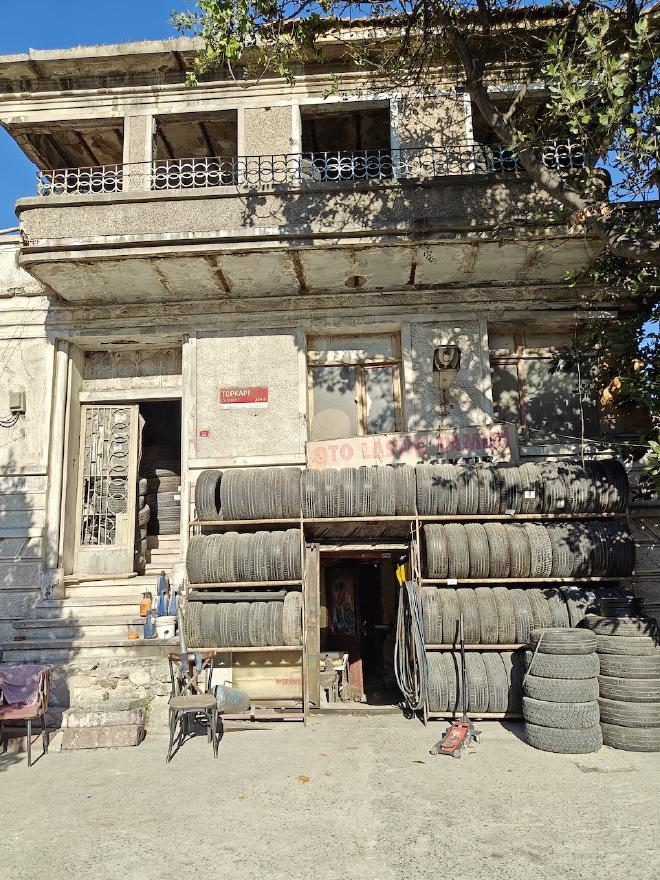 A weathered tire and auto-parts shop in an old stone building, with stacks of tires lining the storefront.
