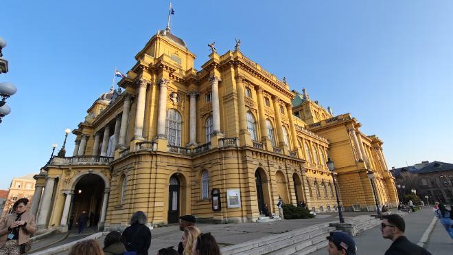 The Croatian National Theatre in Zagreb, a yellow neo-Baroque opera house in late afternoon light.
