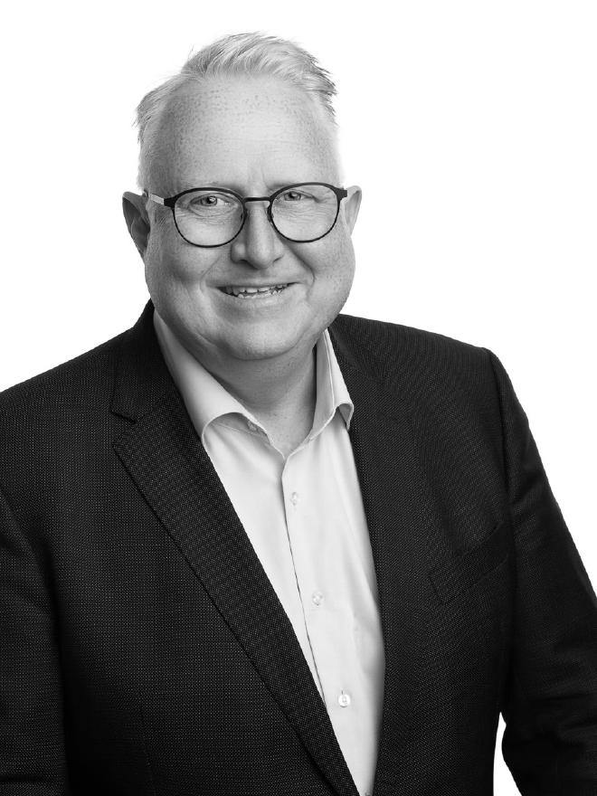 Black-and-white portrait of Kristian Stoffregen in a dark blazer and white shirt